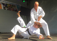 Karateka zeigen fortgeschrittene Partnerübung auf der Bühne